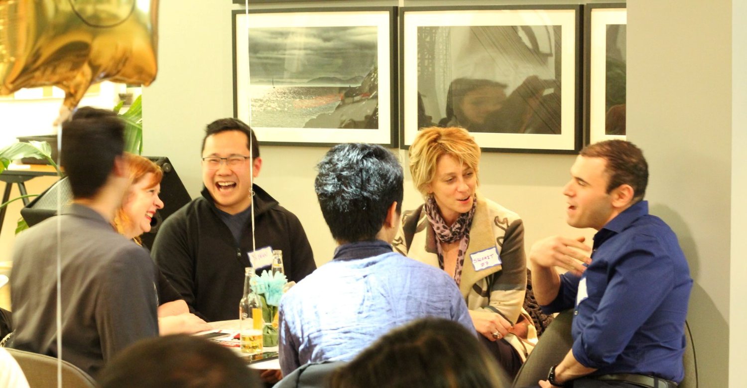 Founders laughing together at a mastermind table